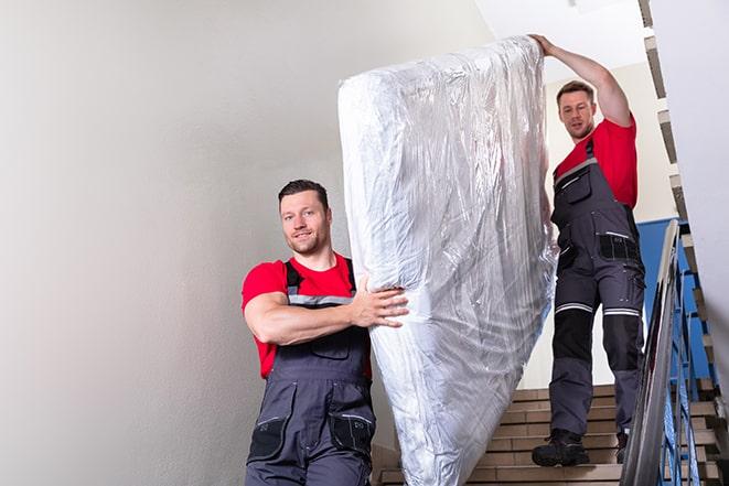 a heavy box spring being carried out of a house in Cottonwood Falls